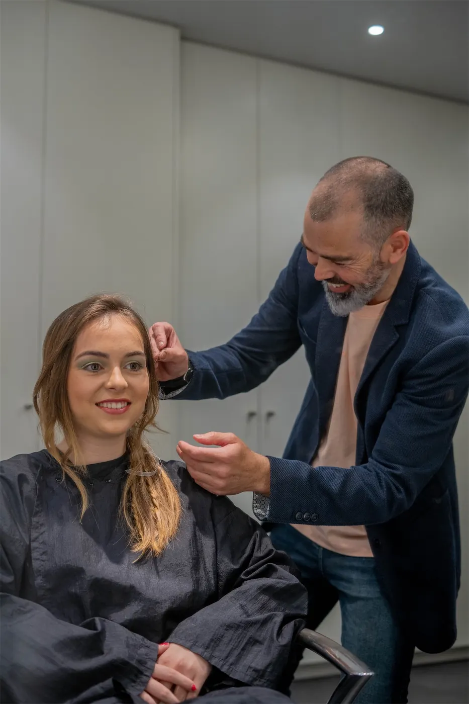 David Suquet tallant els cabells d'una clienta somrient