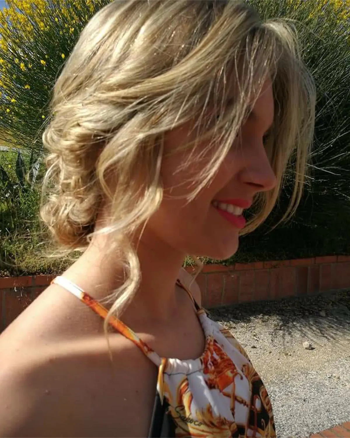 Núvia de perfil amb el cabell recollit i ondulat, a l'aire lliure