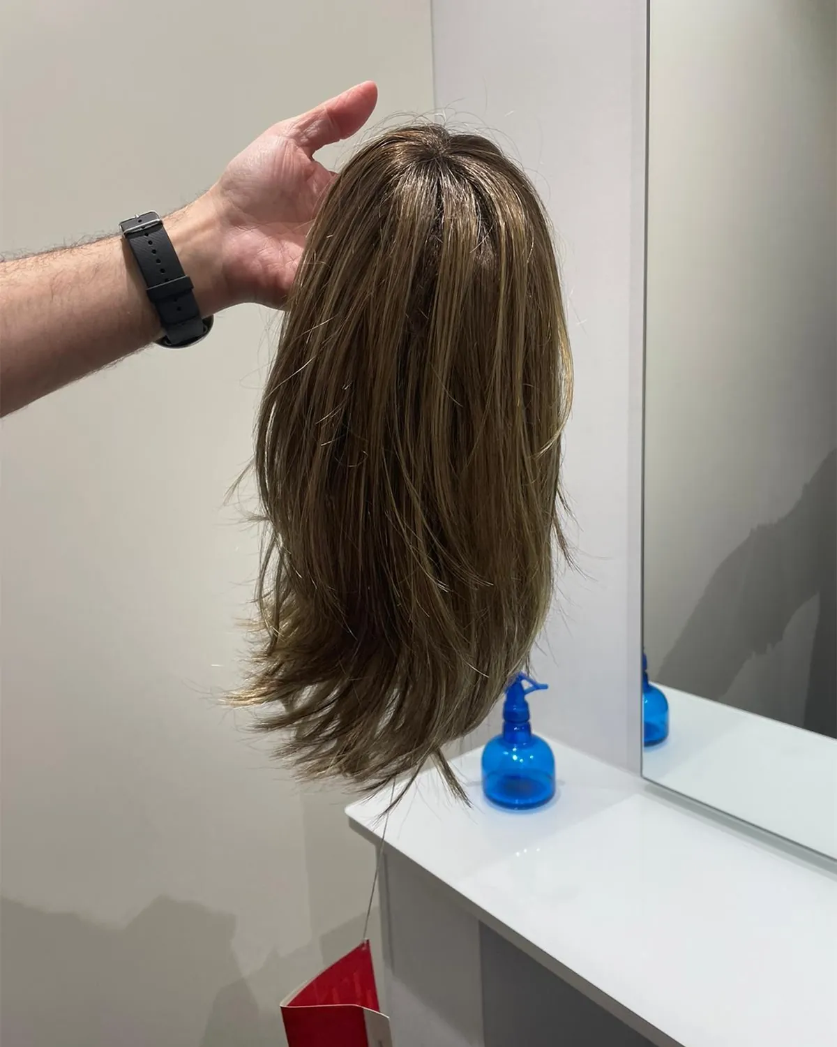 Perruca de cabell natural de mitja melena sobre un suport